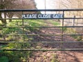 please close gate sign on metal closed gate outside country way Royalty Free Stock Photo