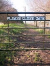 please close gate sign on metal closed gate outside country way Royalty Free Stock Photo