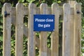Please close gate sign on wooden fence at. children's play park Royalty Free Stock Photo