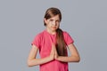 Please darling help me out. Portrait of cute young girl pulling lips down in upset smile, frowning and holding palms in pray while Royalty Free Stock Photo