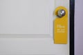Please do not disturb sign hanging on doorknob of white wooden door Royalty Free Stock Photo