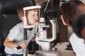 Please don`t move your eyes. Little boy have test for his eyes with special optical apparatus by female doctor Royalty Free Stock Photo