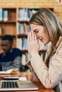 Please dont let me fail this test...a young woman looking stressed while sitting behind a laptop. Royalty Free Stock Photo