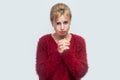 Please forgive me, or help. Portrait of sorry hopeful beautiful young blond woman in red blouse standing and begging or asking for Royalty Free Stock Photo