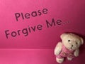 Please forgive me the written note on the pink background with cute sad teddy bear