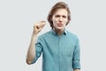 Please gime me a few more. Portrait of hopeful handsome long haired blonde young man in blue casual shirt standing and showing