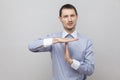 Please give me more time. Pleading handsome bristle businessman in classic blue shirt standing and looking at camera with timeout Royalty Free Stock Photo