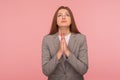 Please, god help! Portrait of imploring young woman in business suit praying, begging with obedient expression Royalty Free Stock Photo