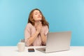 Please, god help! Young woman employee sitting at workplace and keeping eyes closed, praying heartily, pleading Royalty Free Stock Photo