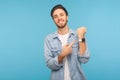 Please, hurry up! Portrait of cheerful punctual man in worker denim shirt pointing at wrist watch and smiling