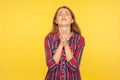 Please I`m begging! Portrait of despaired ginger girl in shirt keeping arms in prayer gesture and holding up head, appealing to Royalty Free Stock Photo