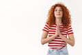 Please I need you. Attractive tender feminine curly redhead woman asking favour press palms pray gesture plead smiling