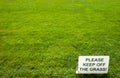 Please keep of the grass lettering sign on green background Royalty Free Stock Photo
