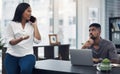 Please keep your voice down, Im trying to work here. a young businessman gesturing for his colleague to be quiet in an Royalty Free Stock Photo