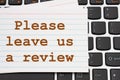 Please leave us a review message white index card on a keyboard Royalty Free Stock Photo