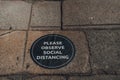 Please observe social distancing sign on a street in London, UK