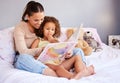 Please read this story mom. a mother reading her daughter her favourite story book. Royalty Free Stock Photo