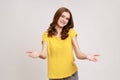 Please, take for free. Friendly pretty young woman in yellow T-shirt welcoming with wide open arms Royalty Free Stock Photo