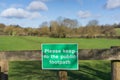 `Please to the public footpath` sign on wooden gate. UK Royalty Free Stock Photo