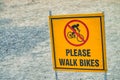 Please walk bikes sign on a trail