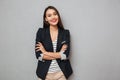 Pleased asian business woman with crossed arms looking at camera