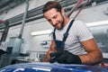 Automotive repairman checking quality of grinded surface