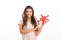 Pleased brunette woman in t-shirt holding gift box