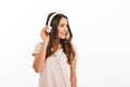 Pleased brunette woman in t-shirt listening music with headphones