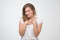 Woman wearing white t-shirt r smiling broadly glad to receive compliments