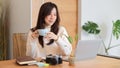 Pleased and cheerful woman drinking morning coffee, relaxation, working on laptop computer Royalty Free Stock Photo