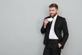 Pleased cool bearded man in suit drinking tea