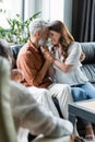 pleased couple embracing on sofa near