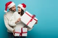 pleased couple in santa hats holding