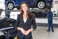 Pleased customer standing in front of her fixed car Royalty Free Stock Photo