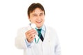 Pleased doctor holding up stethoscope. Close-up.