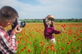 Pleased with each other. man and woman photographing in poppy flower field. summer vacation. happy family. spring nature