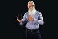 Pleased elderly handsome senior businessman with white beard holding mobile phone with blank empty screen