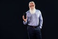Pleased elderly handsome senior businessman with white beard holding mobile phone with blank empty screen, showing device to the Royalty Free Stock Photo