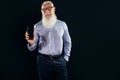 Pleased elderly handsome senior businessman with white beard holding mobile phone with blank empty screen, showing device to the Royalty Free Stock Photo
