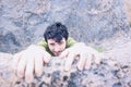 Pleased Face of Man Climbing Over Rock Ledge