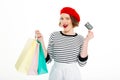 Pleased ginger woman with packages holding credit card