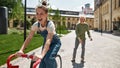 Pleased girl ride bicycle before blurred boyfriend Royalty Free Stock Photo