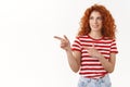 Pleased good-looking sassy flirty redhead stylish curly girl smiling delighted like what see pointing check out left