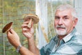 Happy gray-haired man in the kitchen with mushrooms