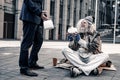 Pleased grey-haired senior homeless sitting covered in rags