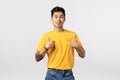 Pleased handsome arrogant asian guy in yellow t-shirt, pointing himself and smiling, employee promoting own abilities