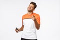 Pleased handsome male fitness instructor pointing camera proud, compliment someone did good job, wear wireless earphones Royalty Free Stock Photo