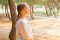 Pleased happy young teenage girl outdoors in beautiful sunny park listening music with headphones Royalty Free Stock Photo