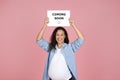 pleased and pregnant woman holding board with coming soon lettering Royalty Free Stock Photo