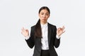 Pleased sassy asian businesswoman in black suit show not bad gesture, nod in approval and make okay gesture, very good
